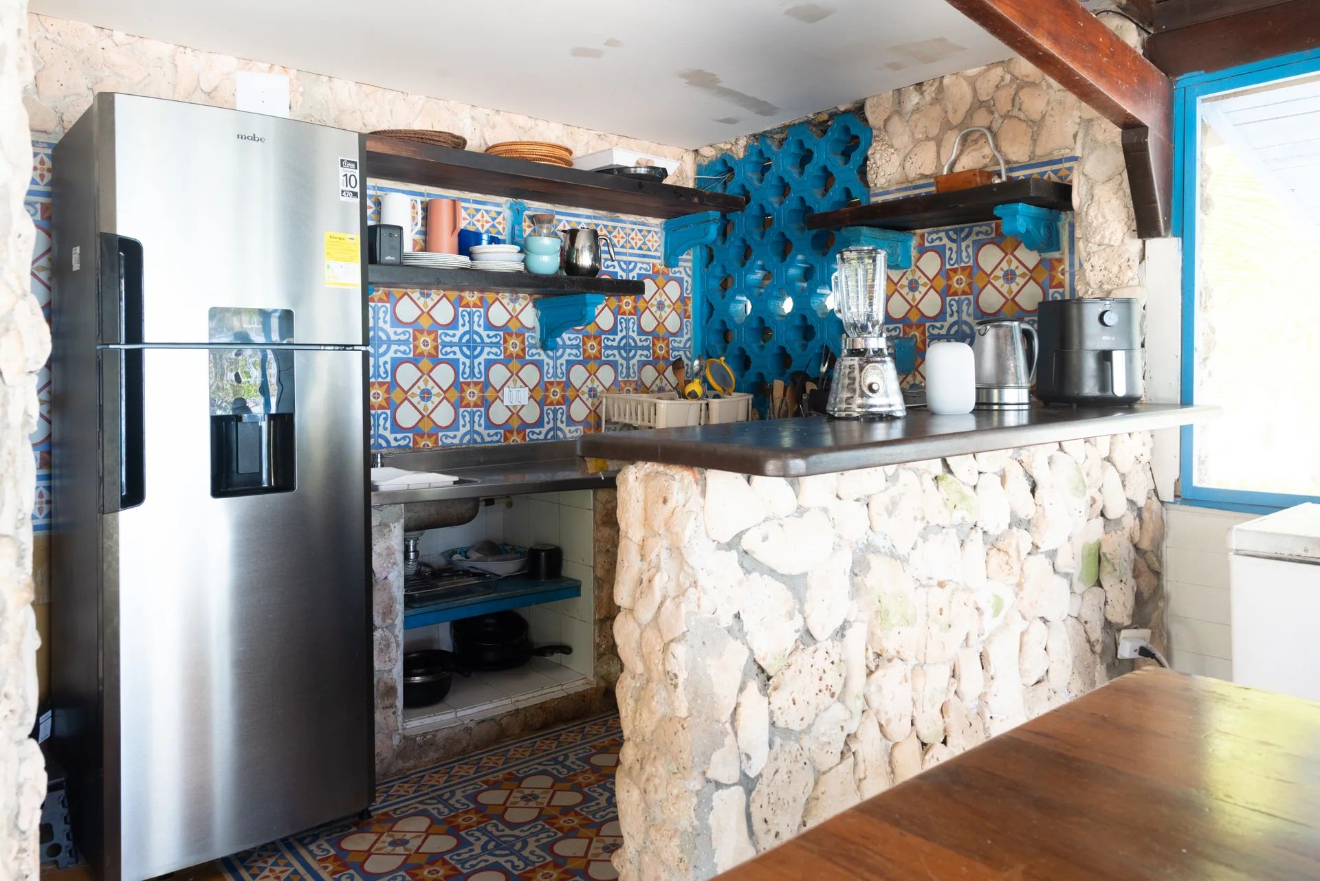 Cocina abierta, barra de piedra y escaleras azules